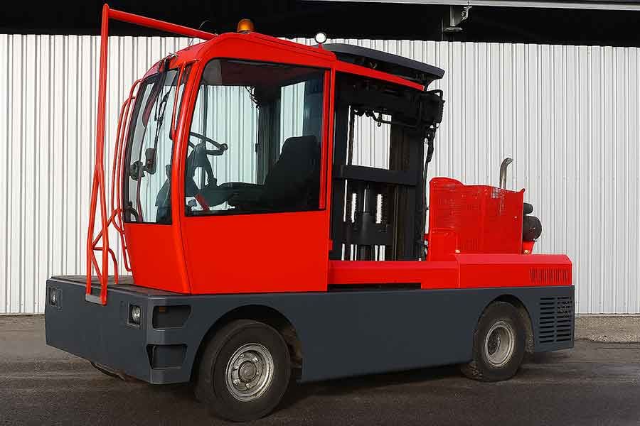 Боковой погрузчик Bulmor DQ 60 с красной кабиной на промышленной площадке