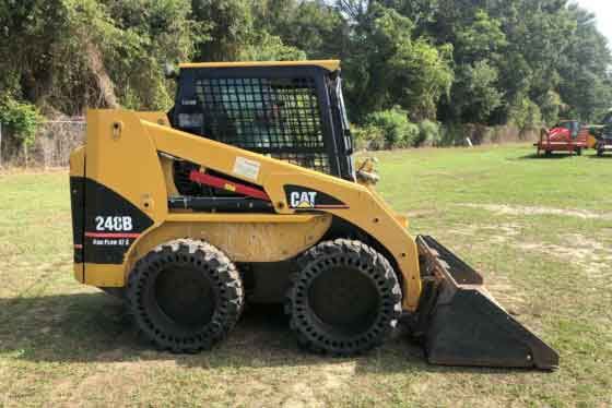 Мини-погрузчик Caterpillar 248B с ковшом на стройплощадке