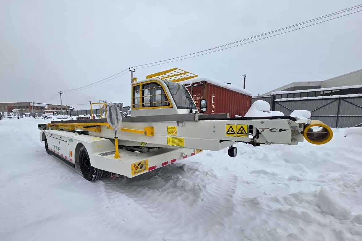Аэродромный ленточный конвейер TCF BLB80 на стоянке в зимних условиях на фоне аэропортовой территории